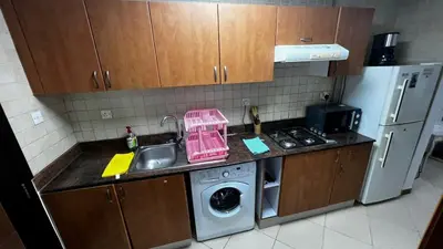 a kitchen with a sink and a washing machine at Dream home in Dubai