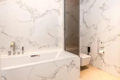 a white bathroom with a tub and a toilet at 3BR with Full Burj Khalifa and Dubai Fountain View at Address Opera in Dubai