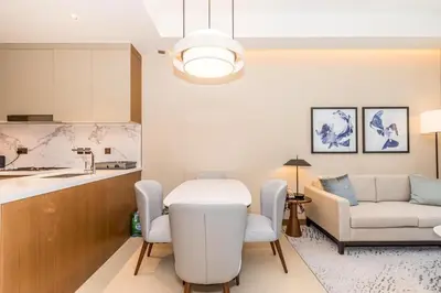 a kitchen and living room with a table and a couch at 3BR with Full Burj Khalifa and Dubai Fountain View at Address Opera in Dubai