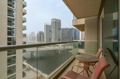 a balcony with a table and chairs and a view of a city at Modern 1BR Unit Close to Canal Walk & Burj Khalifa in Dubai