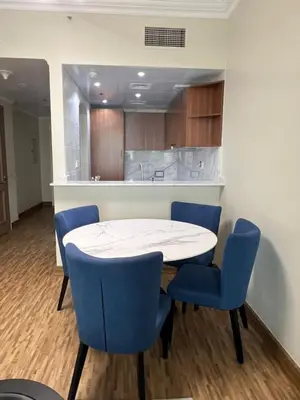 a dining room with a white table and blue chairs at Upgraded Sea View 1BR Dubai Marina, Walk Metro & JBR in Dubai