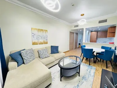 a living room with a couch and a table at Upgraded Sea View 1BR Dubai Marina, Walk Metro & JBR in Dubai