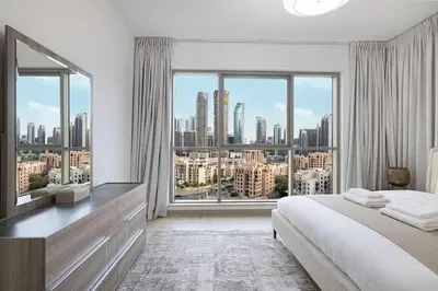 a bedroom with a large bed and a large window at Boulevard Chic Modern 2BR with Iconic Street Views in Dubai