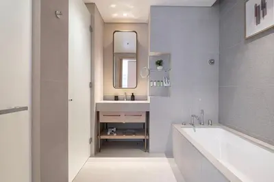 a bathroom with a tub and a sink and a mirror at Iconic Living Contemporary 2BR at Vida Dubai Mall in Dubai