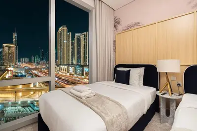 a bedroom with a large window with a city skyline at Downtown Living Massive 4BR at Vida Dubai Mall in Dubai