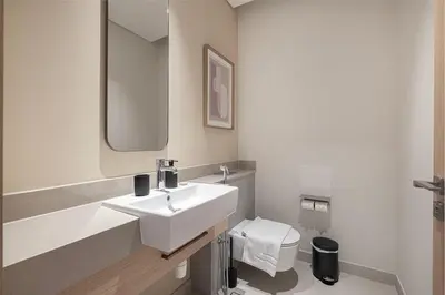a white bathroom with a sink and a toilet at Downtown Living Massive 4BR at Vida Dubai Mall in Dubai