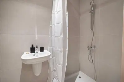 a white bathroom with a sink and a shower at Downtown Living Massive 4BR at Vida Dubai Mall in Dubai
