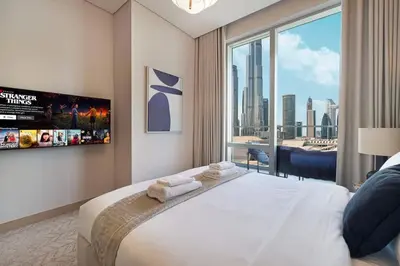 a bedroom with a large bed and a large window at Downtown Living Massive 4BR at Vida Dubai Mall in Dubai