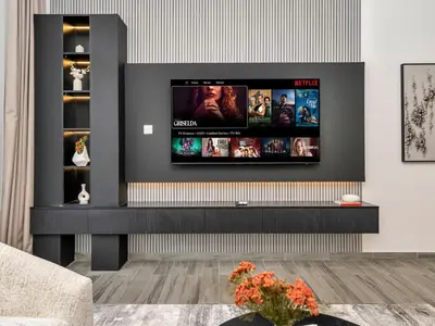 a living room with a flat screen tv on a wall at Royal Vista - 1BR with Darts Wall at Belgravia Square JVC in Dubai