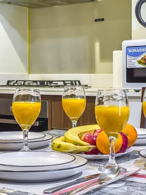 two glasses of orange juice and fruit on a table at Elegant 2BR Business Bay Canal View Gym & Pool in Dubai