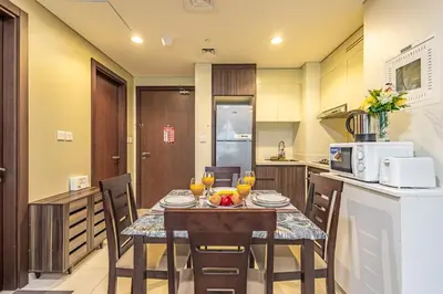a kitchen with a table and chairs in a room at Elegant 2BR Business Bay Canal View Gym & Pool in Dubai