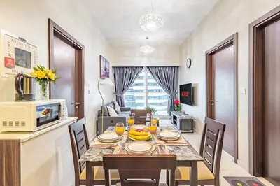 a kitchen and dining room with a table and chairs at Elegant 2BR Business Bay Canal View Gym & Pool in Dubai