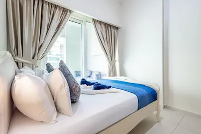 a bedroom with a bed with pillows and a window at Elegant 2BR Business Bay Canal View Gym & Pool in Dubai