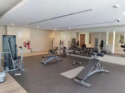 a gym with a large mirror and several tread machines at Elegant 2BR Business Bay Canal View Gym & Pool in Dubai
