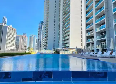 a large swimming pool in a city with tall buildings at Elegant 2BR Business Bay Canal View Gym & Pool in Dubai