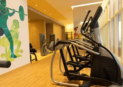 a gym with cardio equipment in a building at Elite Studio with Kitchen in Novotel JVT in Dubai