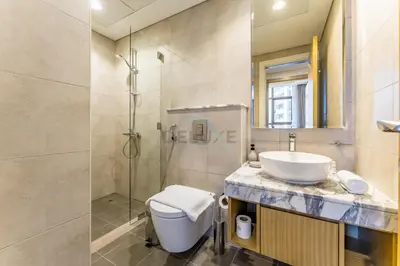 a bathroom with a toilet and a sink and a shower at Near Safa Park, Offering Easy Access to Downtown Dubai, Jumeirah Beach and Kite Beach - Aykon City 2 Tower C, Business Bay by Deluxe Holiday Homes in Dubai