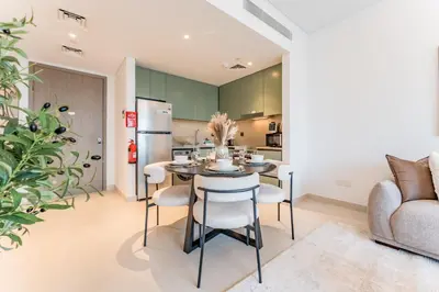 a kitchen and dining room with a table and chairs at Just Moments from Coca-Cola Arena and Metro 1BR, Surrounded by a Vibrant Array of Retail and Dining Outlets, Viridian, Al Wasl by Deluxe Holiday Homes in Dubai