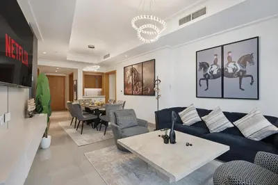a living room with a blue couch and a table at Luxury 4BR Apartment Burj Khalifa & Mall Views in Dubai