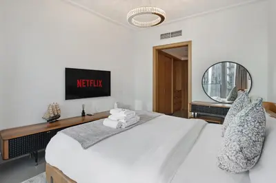 a bedroom with a white bed and a mirror at Luxury 4BR Apartment Burj Khalifa & Mall Views in Dubai