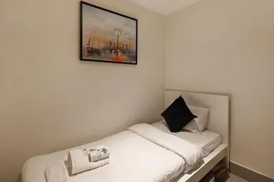 a bedroom with a white bed with a picture on the wall at Luxury 4BR Apartment Burj Khalifa & Mall Views in Dubai