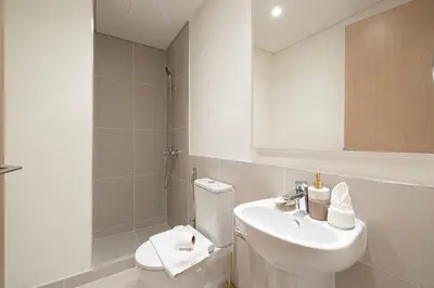 a bathroom with a sink and a toilet and a mirror at 3 Bedroom Apartment with Full Skyline Views In Creek Harbour in Dubai