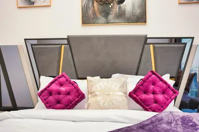 a bed with three pillows on top of it at ROME x DXB with Full Burj and Fountain View in Downtown Dubai in Dubai