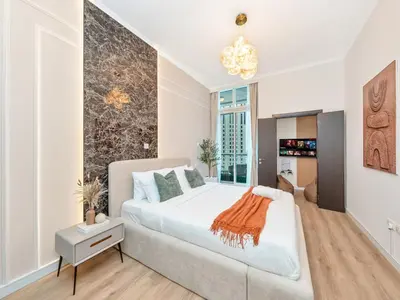a bedroom with a large white bed and a chandelier at Ultra Stylish Luxury Flat w Harbour View in Dubai Marina, Sleeps 10 pax in Dubai
