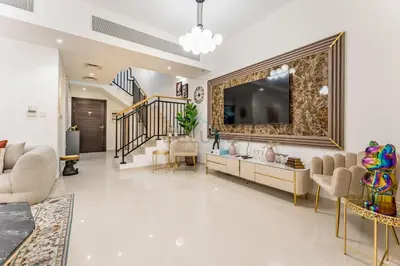 a living room with a tv on a wall at Well-Connected, Family-Friendly Community with Resort-Style Amenities, Minutes from Major Malls and Al Maktoum International Airport - Damac Hills 2 Amargo, Damac Hills 2 by Deluxe Holiday Homes in Dubai