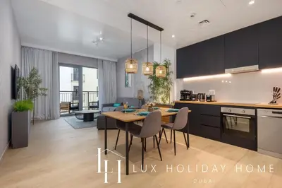 a kitchen and living room with a table and chairs at LUX The La Mer Beach Suite 5 in Dubai