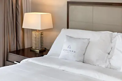 a bed with white pillows and a table with a lamp at Marriott 1BR Apartment with Dubai Marina View in Dubai