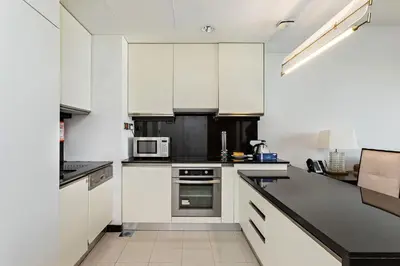 a kitchen with white cabinets and a microwave at Marriott 1BR Apartment with Dubai Marina View in Dubai