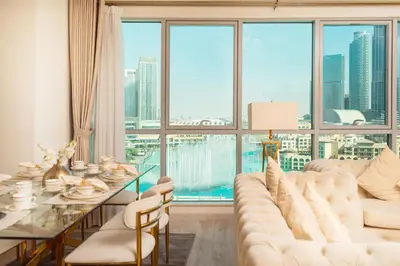 a living room with a table and a large window at Elite Royal Apartment - Sky Series - Panoramic New Fountain & Burj Khalifa View - Nebuchadnezzar II in Dubai