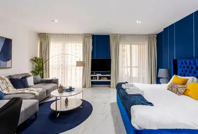 a blue bedroom with a large bed and a couch at Ahlan Marhaba Marina JBR in Dubai