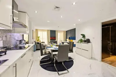 a kitchen and living room with a table and chairs at Ahlan Marhaba Marina JBR in Dubai