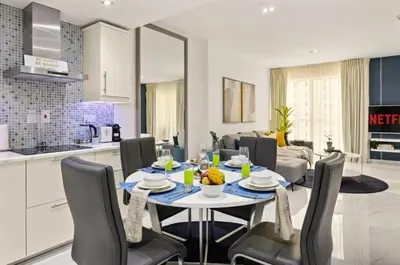 a kitchen and living room with a table and chairs at Ahlan Marhaba Marina JBR in Dubai