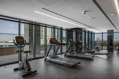 a gym with several tread machines in a building with windows at Stylish Missoni Studio with Direct Pool Access in Dubai