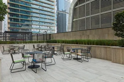 a patio with tables and chairs and buildings at Stylish Missoni Studio with Direct Pool Access in Dubai