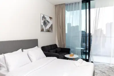a bedroom with a bed and a couch and a chair at Modern Studio Apartment - Binghatti Azure 633 in Dubai
