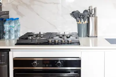 a stove top oven sitting on top of a kitchen counter at Modern Studio Apartment - Binghatti Azure 633 in Dubai
