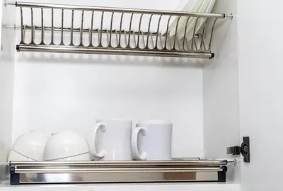 a metal shelf with cups and mugs on it at Modern Studio Apartment - Binghatti Azure 633 in Dubai