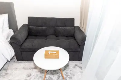 a living room with a couch and a table at Modern Studio Apartment - Binghatti Azure 633 in Dubai