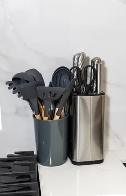 two metal containers filled with utensils on a counter at Modern Studio Apartment - Binghatti Azure 633 in Dubai