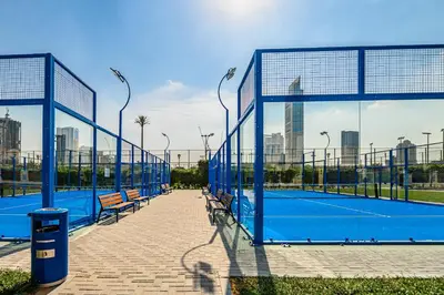 a tennis court with two benches and a tennis court at Apartment-Private Bathroom in Dubai