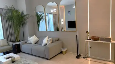 a living room with a couch and two mirrors at Boulevard Sea View Luxury 1 BR Next Dubai Mall in Dubai