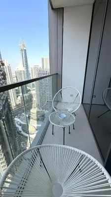 a balcony with a table and a chair on a building at Boulevard Sea View Luxury 1 BR Next Dubai Mall in Dubai