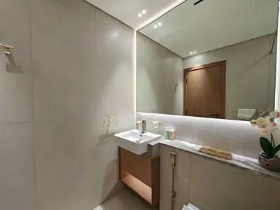 a bathroom with a sink and a mirror at Brand New High Floor 1 BR with city view, pool and gym in Dubai