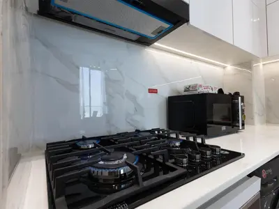 a stove top oven in a kitchen with a microwave at Brand New High Floor 1 BR with city view, pool and gym in Dubai