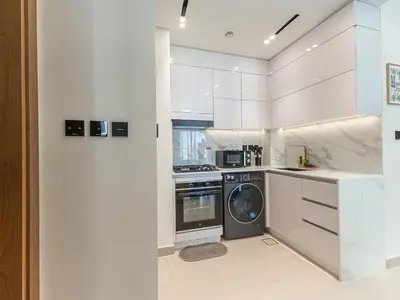 a white kitchen with a washer and a dishwasher at Brand New High Floor 1 BR with city view, pool and gym in Dubai