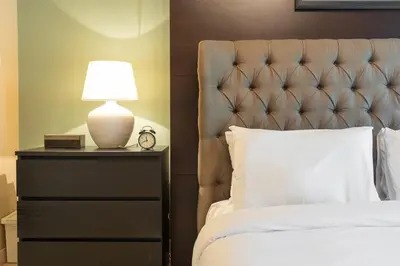 a bedroom with a bed and a lamp on a dresser at StayShort - Majestic 4BR in Dubai Marina - Sleeps 8 in Dubai